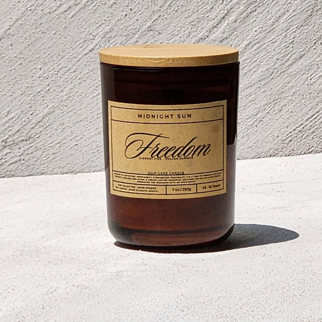 Candle with a wooden lid and 'Freedom' label on a light surface.
